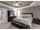 Primary bedroom with a tray ceiling, large bed, and dresser at 333 Bald Head Island Dr, Garner, NC 27529