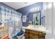 Bathroom featuring blue wallpaper, a shower with a decorative curtain, and ample storage at 3608 Meadow Creek Ln, Raleigh, NC 27616