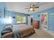 Airy bedroom featuring blue walls, a ceiling fan, and a walk-in closet for ample storage at 3608 Meadow Creek Ln, Raleigh, NC 27616
