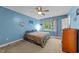 Sunny bedroom featuring blue walls, a ceiling fan, and a window for natural light at 3608 Meadow Creek Ln, Raleigh, NC 27616
