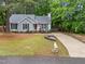 Well-maintained single-story home with a long driveway, manicured lawn, and mature trees at 3608 Meadow Creek Ln, Raleigh, NC 27616