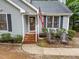 Inviting front porch with brick steps, outdoor seating, and a well-maintained garden at 3608 Meadow Creek Ln, Raleigh, NC 27616