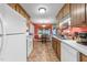 Functional kitchen featuring white appliances, wooden cabinets, and a view into the dining area at 3608 Meadow Creek Ln, Raleigh, NC 27616