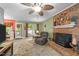Cozy living room featuring a brick fireplace, neutral carpet, and access to the outdoor deck at 3608 Meadow Creek Ln, Raleigh, NC 27616