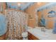 Quaint bathroom with beach themed shower curtain, sink, and decorative accents, providing a unique touch at 403 Rolling Rd, Haw River, NC 27258