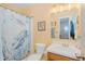 Cozy bathroom features a vanity, toilet, framed mirror, and decorative shower curtain, offering a functional space at 403 Rolling Rd, Haw River, NC 27258