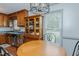 A simple dining area has a round table, an elegant light fixture, and a view into the yard at 403 Rolling Rd, Haw River, NC 27258