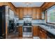Traditional kitchen features wood cabinets, stainless steel appliances, and hardwood floors at 403 Rolling Rd, Haw River, NC 27258