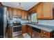 The kitchen is equipped with stainless steel appliances, a stainless steel sink, and oak cabinets at 403 Rolling Rd, Haw River, NC 27258