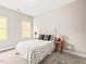 Cozy bedroom featuring carpeted floors, two windows, and a comfortable bed with pillows and lamps at 404 S Camellia St, Chapel Hill, NC 27516