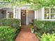 Charming front porch with brick pathway, rocking chair and manicured landscaping at 404 S Camellia St, Chapel Hill, NC 27516