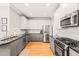 Bright kitchen with stainless steel appliances, granite countertops, and gray and white cabinets at 404 S Camellia St, Chapel Hill, NC 27516