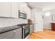 Modern kitchen with stainless steel oven, gray cabinets, granite countertops, and hardwood floors at 404 S Camellia St, Chapel Hill, NC 27516