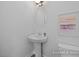Bathroom featuring a pedestal sink, modern lighting, and framed art at 428 Longleaf Glen Lane, Zebulon, NC 27597