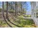 Well-maintained backyard with grassy lawn, patio, and an outdoor dining set surrounded by trees at 4508 Cobble Creek Ln, Raleigh, NC 27616