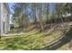 Spacious backyard with lawn, patio and table is framed by tall trees on a bright sunny day at 4508 Cobble Creek Ln, Raleigh, NC 27616