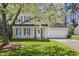 Inviting two-story home with blue shutters, yellow door, and a lovely blooming tree in the yard at 4508 Cobble Creek Ln, Raleigh, NC 27616
