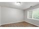 Bright bedroom with wood-look floors, a ceiling light, and large windows for natural light at 4812 Kaplan Dr, Raleigh, NC 27606