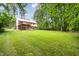 Expansive backyard showcasing a well-maintained lawn and a charming two-story home with a deck at 5001 Simpson Dr, Sanford, NC 27330