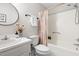 Bathroom featuring a round mirror, vanity with flowers, and a white shower-tub combo at 5001 Simpson Dr, Sanford, NC 27330