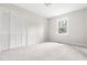This bedroom features neutral carpet, a bright window, and bi-fold doors to a closet at 5001 Simpson Dr, Sanford, NC 27330