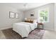 Bright bedroom with large window, neutral walls, comfortable bed, decorative pillows, and ceiling fan at 5001 Simpson Dr, Sanford, NC 27330