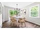 Dining room with wood floors, modern light fixture, white table set, and sliding glass doors at 5001 Simpson Dr, Sanford, NC 27330