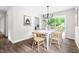 Bright dining area with white table, wood chairs, modern chandelier, and sliding doors to outdoor deck at 5001 Simpson Dr, Sanford, NC 27330