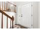 Entryway with white front door, hardwood floors, white trim, and wood banister at 5001 Simpson Dr, Sanford, NC 27330