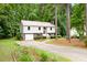 Split level home with beige siding, brick accents, metal roof, driveway, and mature landscaping at 5001 Simpson Dr, Sanford, NC 27330