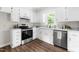 Bright kitchen featuring stainless steel appliances, white cabinets, modern hardware, and wood-look flooring at 5001 Simpson Dr, Sanford, NC 27330