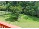 View of the backyard with green grass, trees, privacy fence and deck at 5016 Trembath Ln, Cary, NC 27519