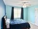 A bedroom with light blue walls, a ceiling fan, and a window with dark curtains creates a calming atmosphere at 5016 Trembath Ln, Cary, NC 27519