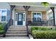 Inviting front porch with stone detail, stylish seating, and covered entryway at 5016 Trembath Ln, Cary, NC 27519