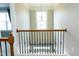 Hallway with wrought iron railing and chandelier at 5016 Trembath Ln, Cary, NC 27519