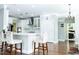 Open kitchen with white cabinets, stainless steel appliances, island seating, and hardwood floors provides a great layout at 5016 Trembath Ln, Cary, NC 27519
