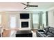 Inviting living room features a cozy fireplace, ceiling fan, and hardwood flooring at 5016 Trembath Ln, Cary, NC 27519