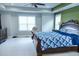 This primary bedroom has a plush carpet, large windows, and a ceiling fan at 5016 Trembath Ln, Cary, NC 27519
