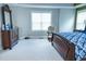 The primary bedroom features carpet flooring, large windows, dresser with mirror, and a chair at 5016 Trembath Ln, Cary, NC 27519