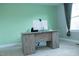 Home office with green accent wall, carpet, window, and wood-look desk with computer at 5016 Trembath Ln, Cary, NC 27519