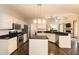 Open kitchen layout features white cabinets, granite countertops, an island and stainless appliances at 5609 Barham Ct, Raleigh, NC 27613