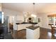 Bright kitchen featuring white cabinetry, black countertops, and an island with pendant lighting at 5609 Barham Ct, Raleigh, NC 27613