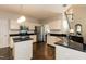 This kitchen features stainless appliances, an island, white cabinets, and hardwood floors at 5609 Barham Ct, Raleigh, NC 27613