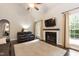 Spacious living room with a fireplace, a mounted TV, hardwood floors, and lots of natural light at 5609 Barham Ct, Raleigh, NC 27613