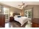 Comfortable bedroom featuring hardwood floors, a ceiling fan, and ample natural light at 5609 Barham Ct, Raleigh, NC 27613