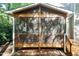 Inviting screened porch with wood frame, railing, and steps leading to the backyard at 5609 Barham Ct, Raleigh, NC 27613
