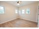 Bedroom featuring a ceiling fan, three windows, and wood floors at 6 1St St, Franklinton, NC 27525