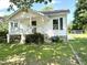 Quaint home exterior showcasing a well-maintained lawn, inviting front porch, stone steps and charming shrubbery at 6 First St, Franklinton, NC 27525