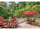 Inviting backyard deck features patio furniture and a red umbrella, perfect for outdoor dining at 605 Bear Tree Crk, Chapel Hill, NC 27517