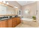 Bathroom showcasing double vanity, soaking tub, and travertine tile at 605 Bear Tree Crk, Chapel Hill, NC 27517